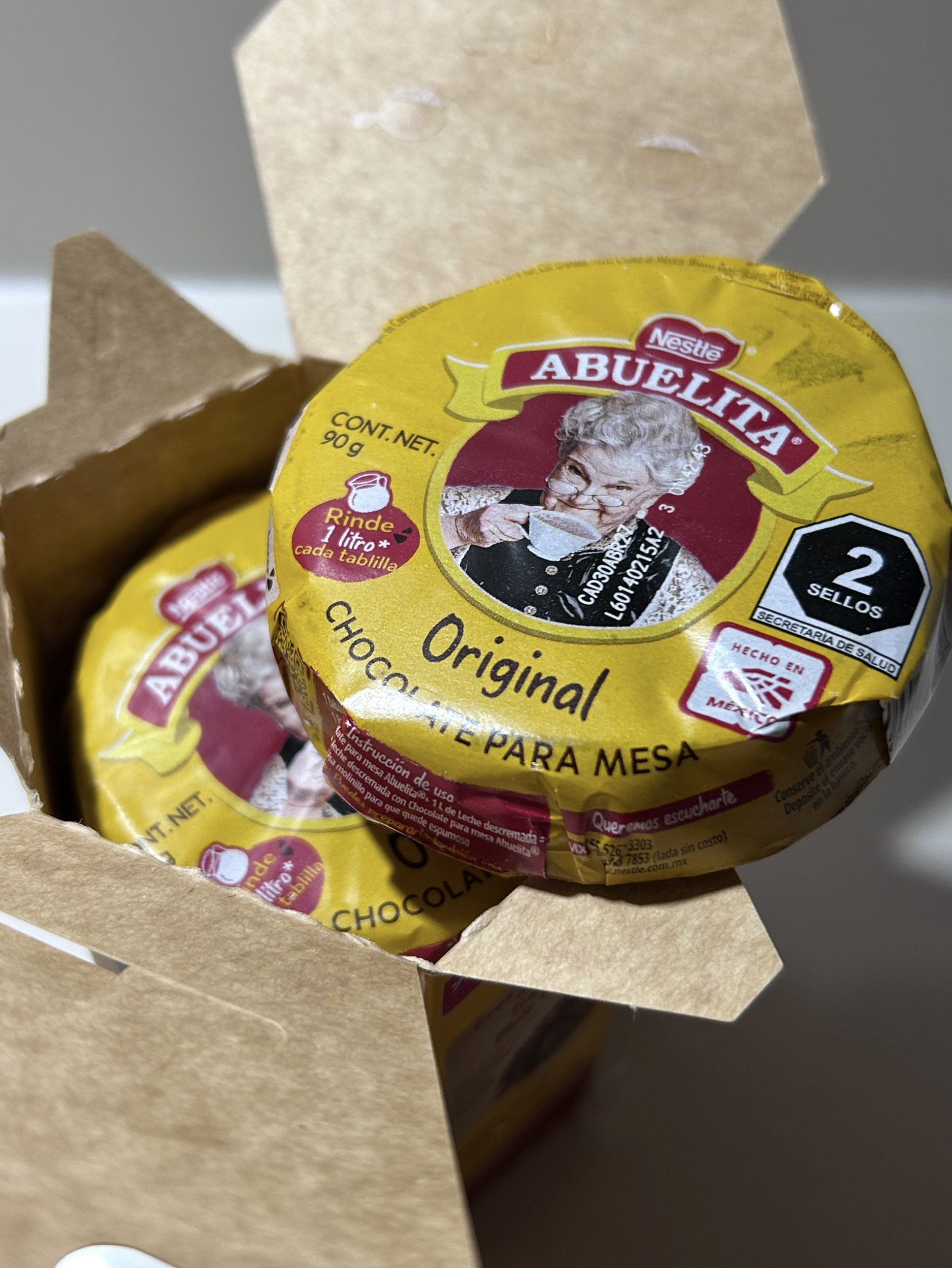 Individually wrapped ABUELITA chocolate tablets inside the box